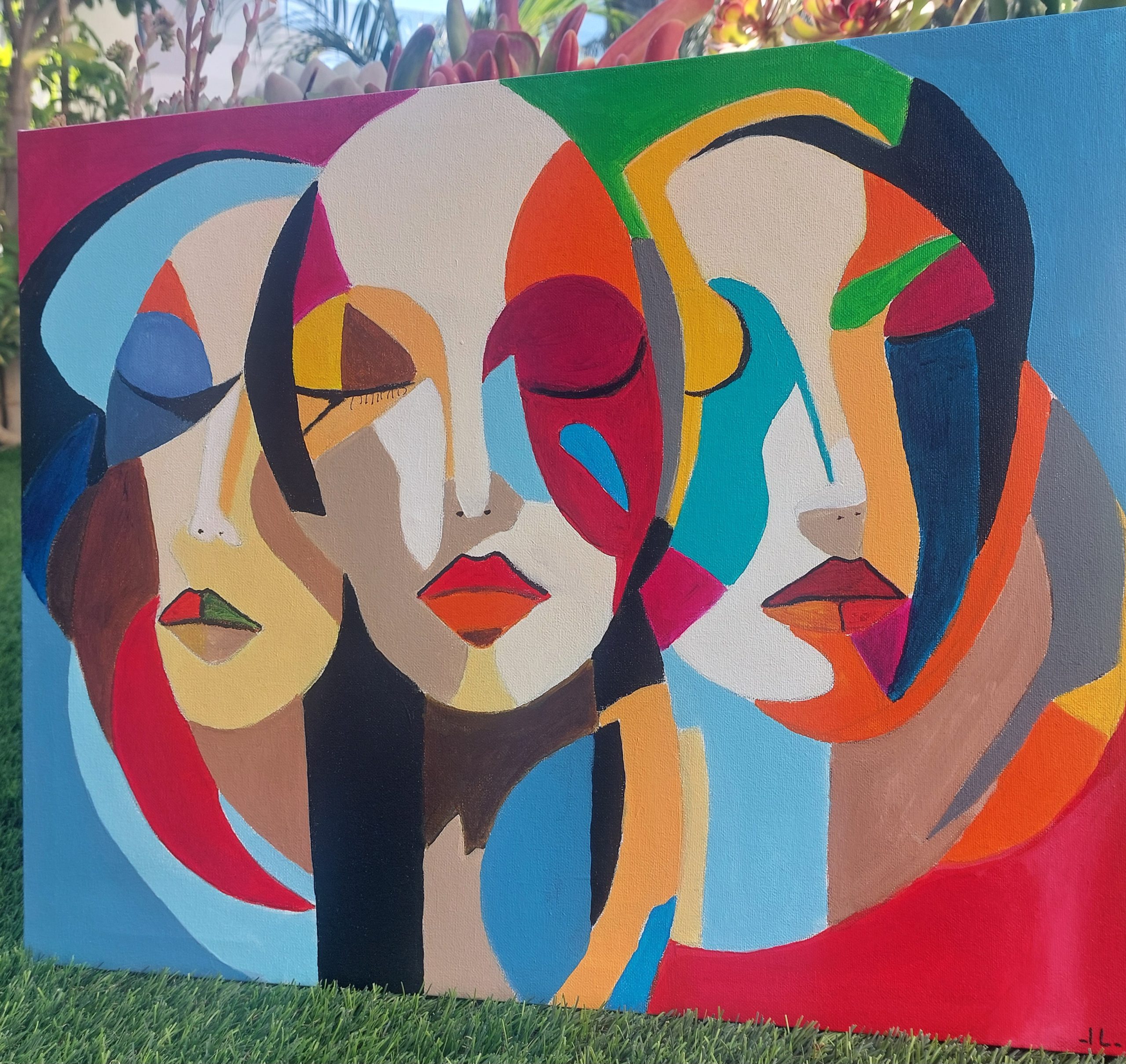Een kleurrijk abstract schilderij met drie gestileerde gezichten in kubistische stijl, gekenmerkt door gedurfde kleurvlakken en vloeiende lijnen.